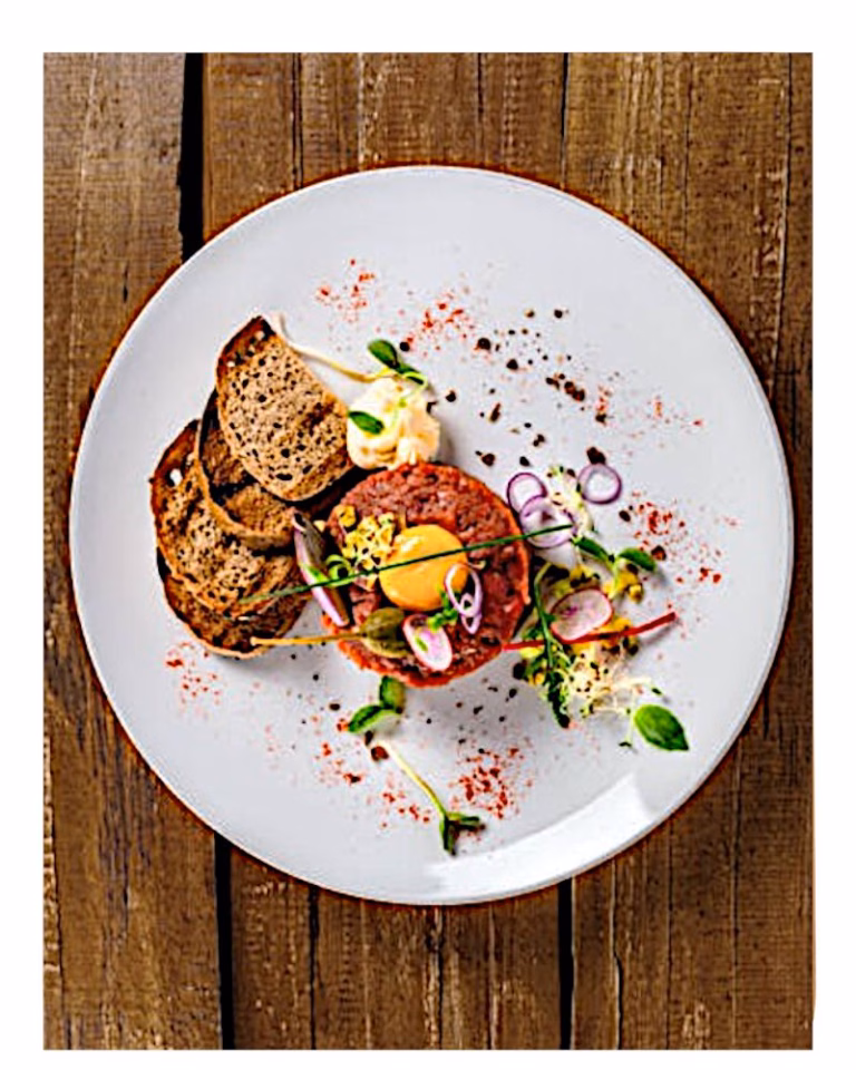 Rindertatar mit Brot und Garnitur