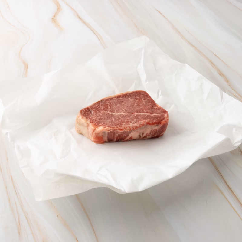 Stück rotes Fleisch auf Papier, wagyu filet steak