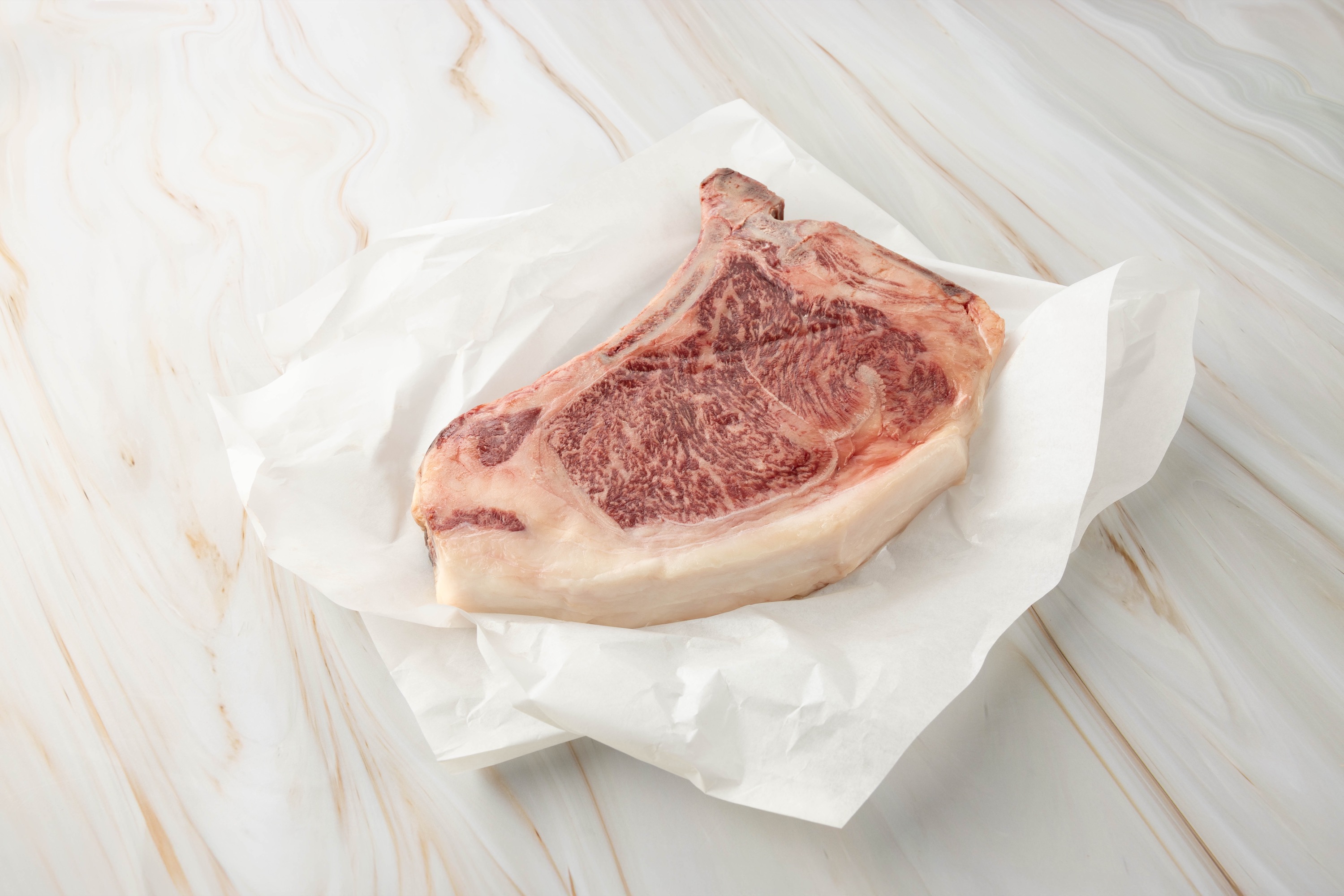 Rohes Clubsteak auf weißem Papier