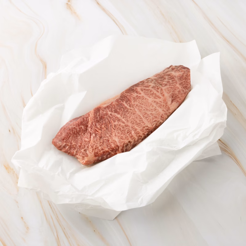 Rohes Fleischstück auf weißem Papier, wagyu denver cut