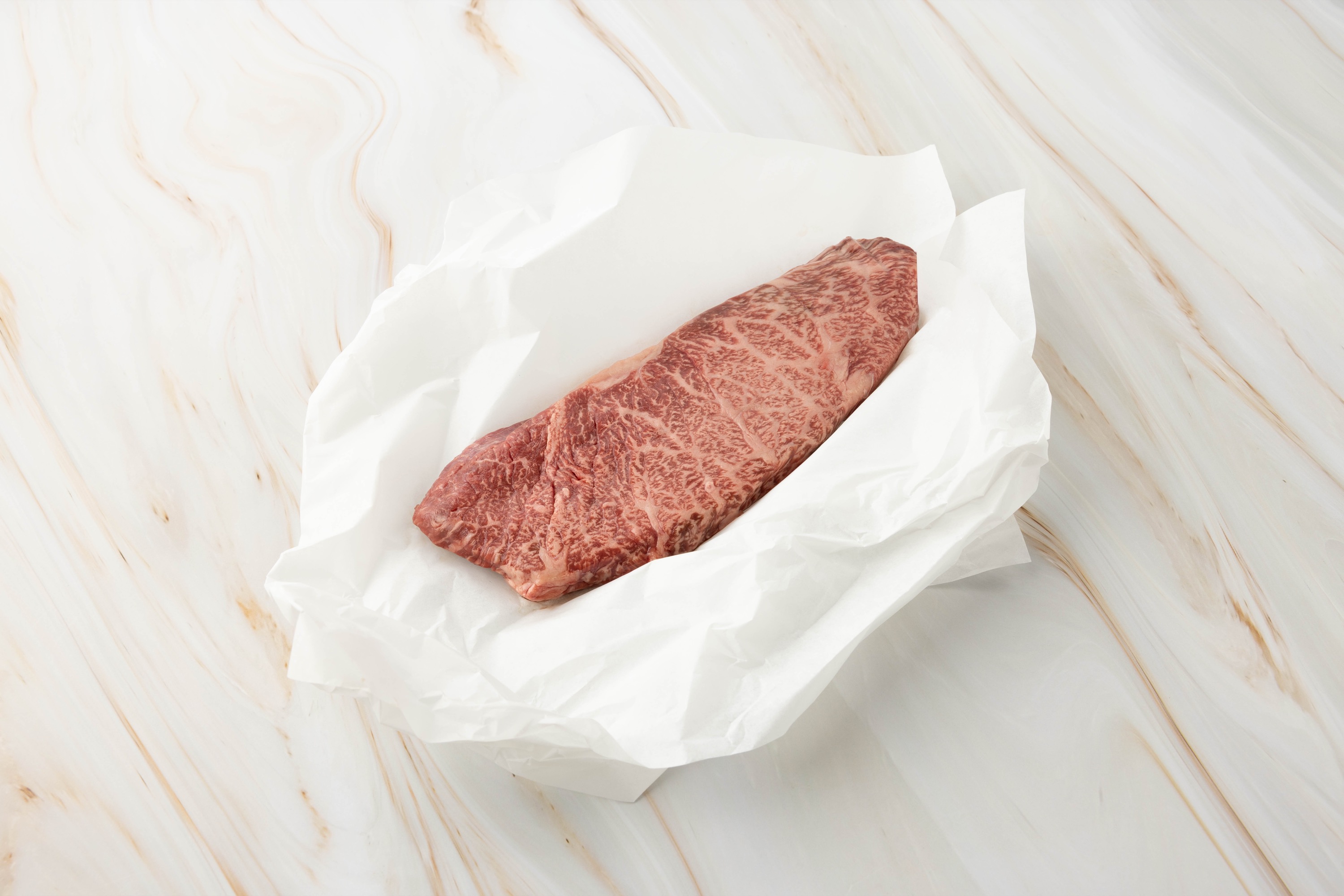 Rohes Fleischstück auf weißem Papier