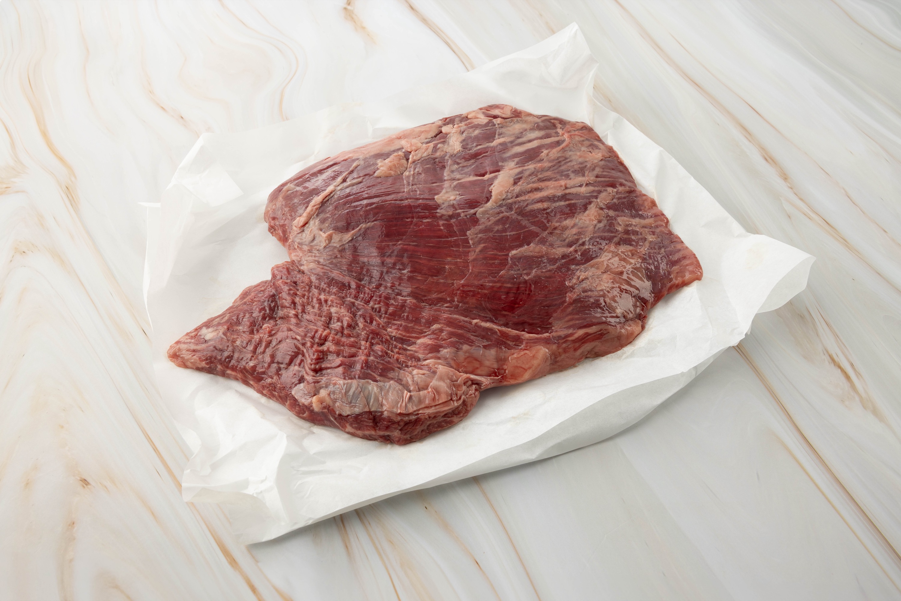 Rohes Flanksteak auf Papier