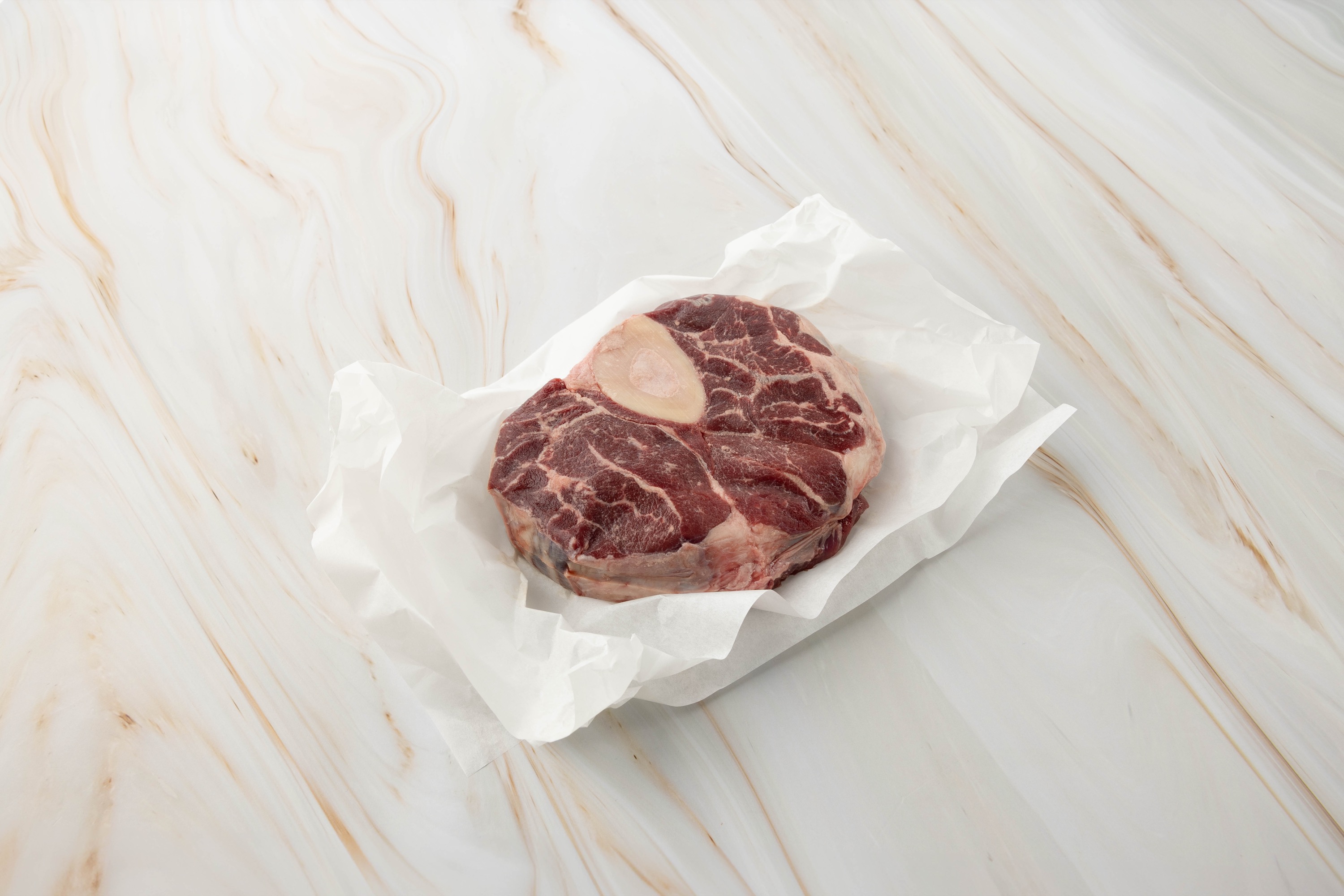 Rohes Ossobuco auf weißem Papier