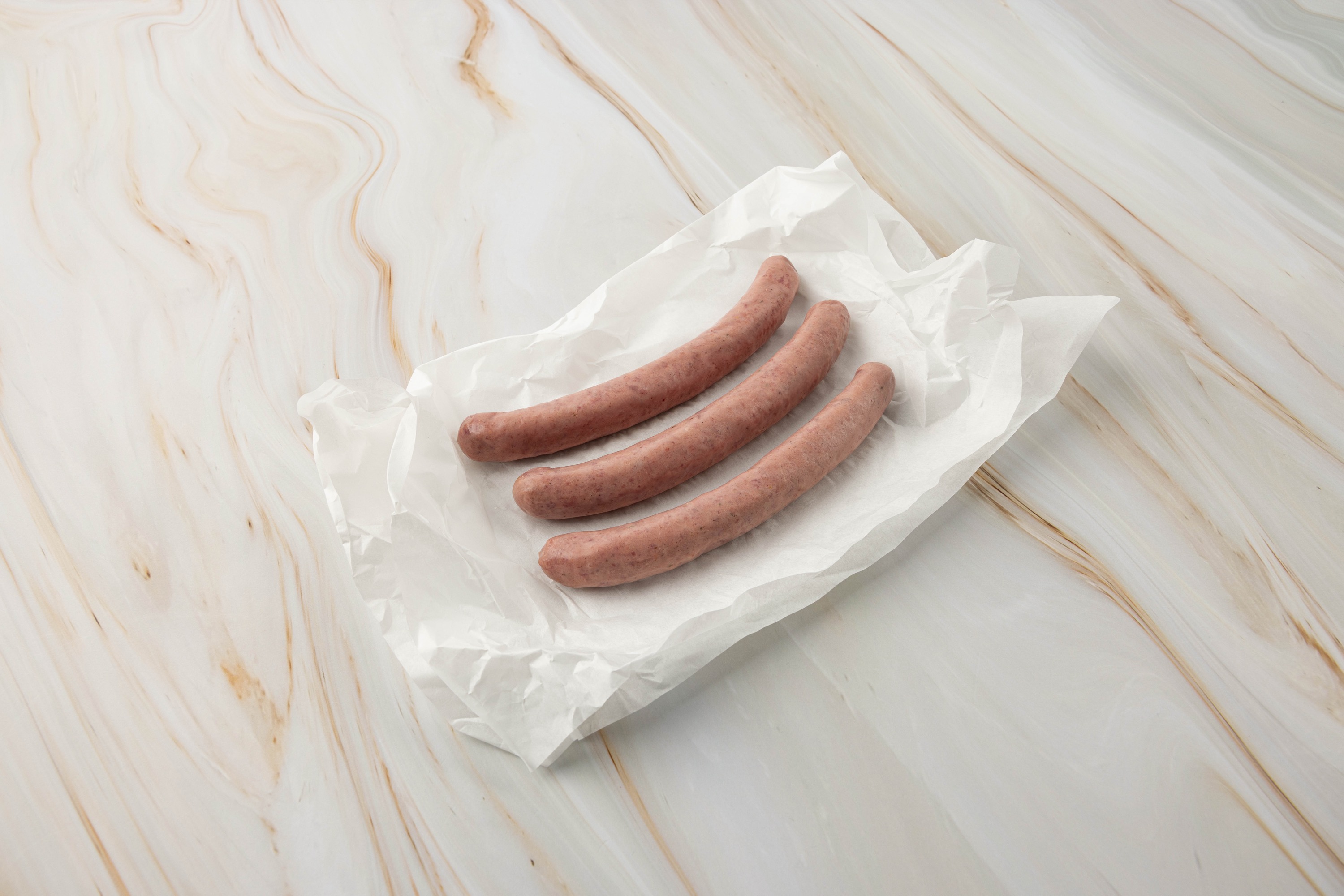 Drei ungekochte Würstchen auf Papier