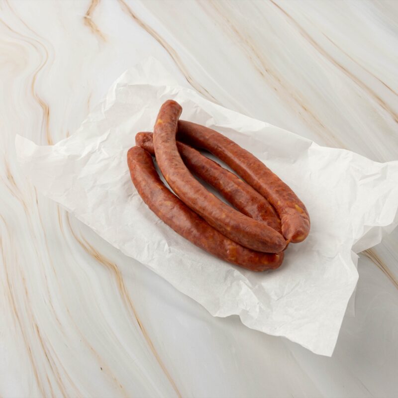 Rohwürste auf weißem Papier, wagyu käsekrainer