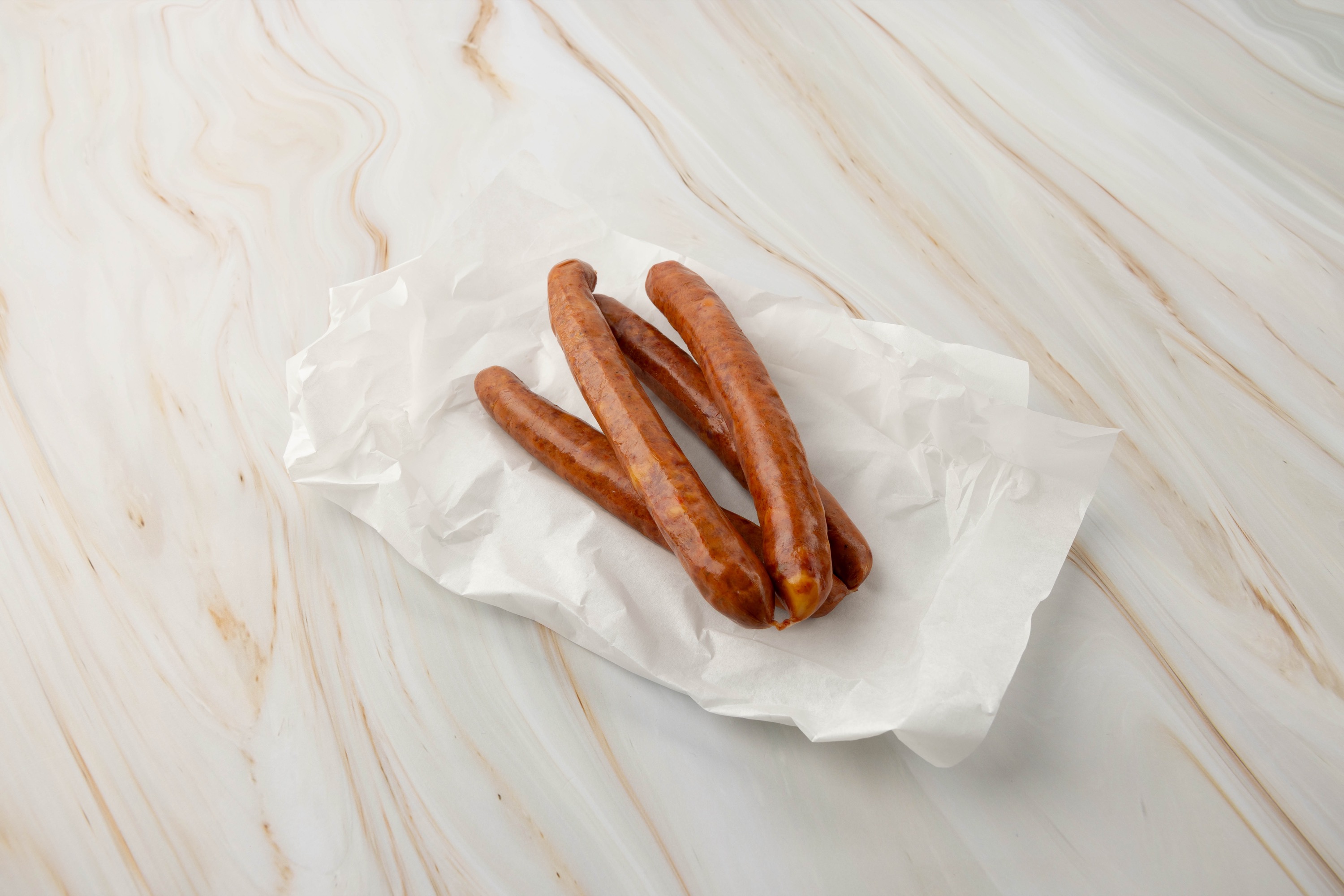 Drei Würstchen auf weißem Papier, cheese-jalapeno-krainer, chili-cheese-krainer