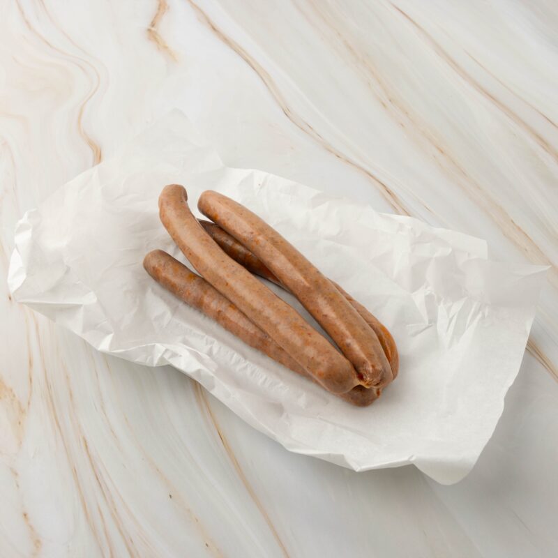 Drei würzige Bratwürste auf Papier