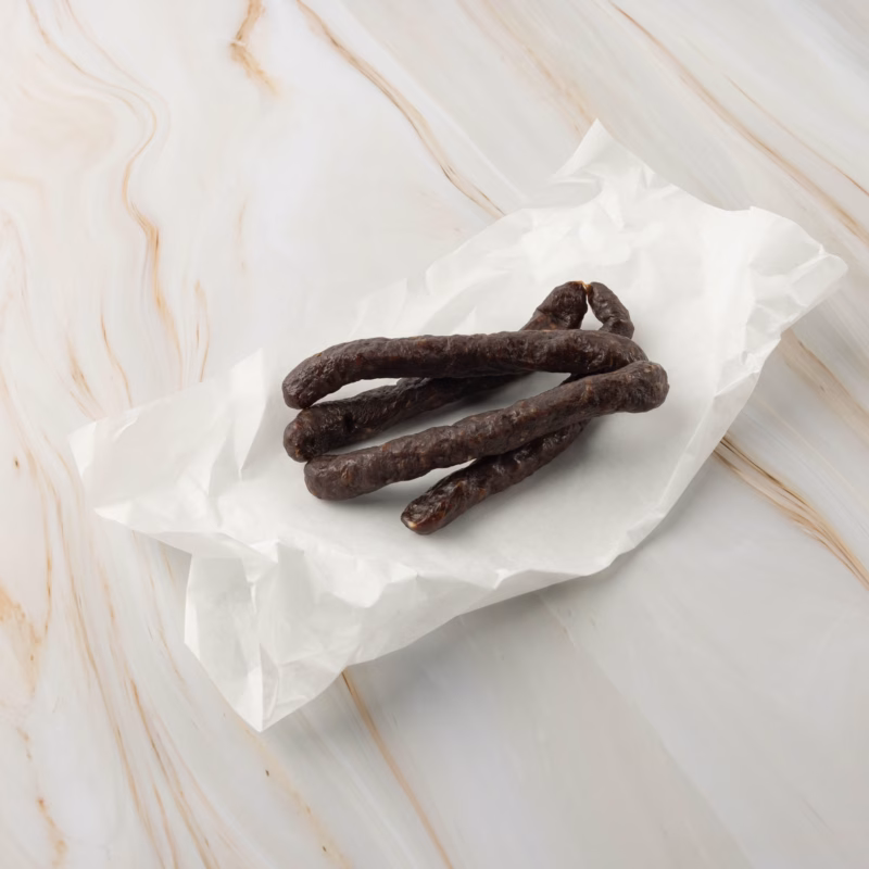 Dunkle, dünne Wurst auf Papier wagyu beisser