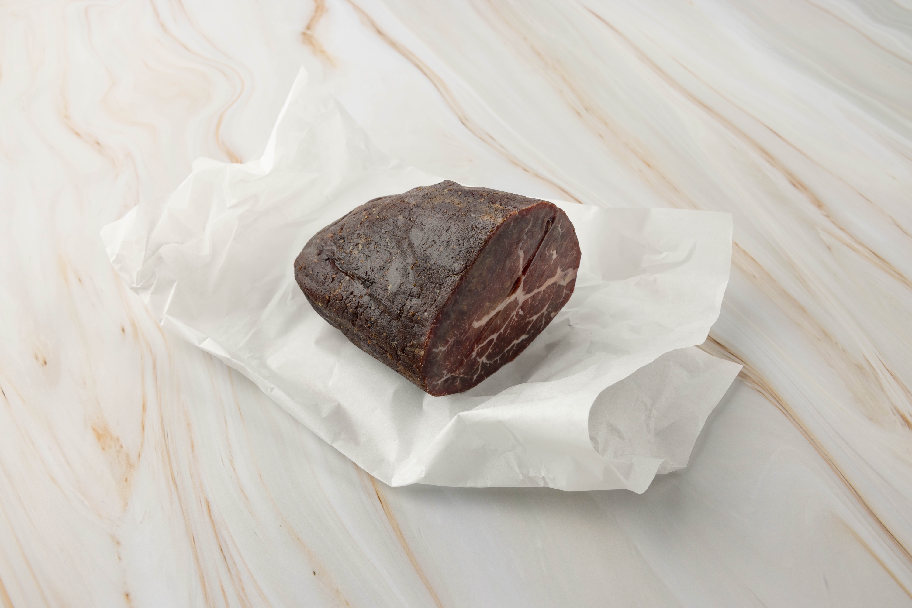 Stück Speck auf weißem Papier