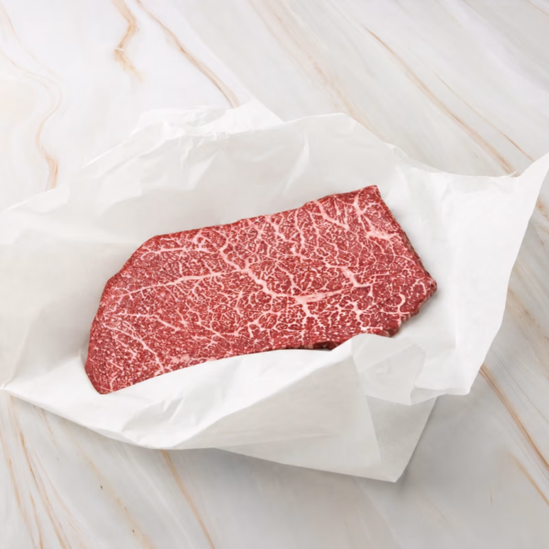 rohes fleisch auf weißem papier, wagyu top round steak